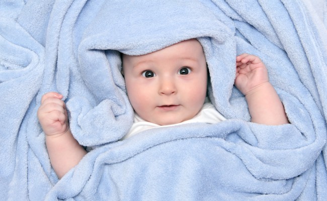 beautiful baby after bath under a blanket